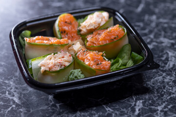 set of sushi rolls with seafood on a black stone background