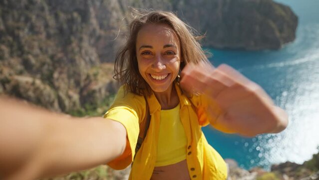 Beautiful happy woman making selfie outdoors sharing travel adventure, taking picture for social media, enjoying vacation at Butterfly Valley in Turkey