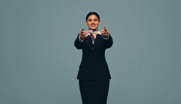 Flight attendant pointing at the camera in a studio