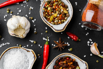 Garlic cloves and spices on black background