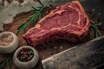 Obraz premium food concept of raw beef steak with rosemary on top of wooden board