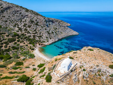 Aerial view of the small beach of Armeas next to Galissas with the picturesque church of Agios Pakos, Syros island, Cyclades, Greece
