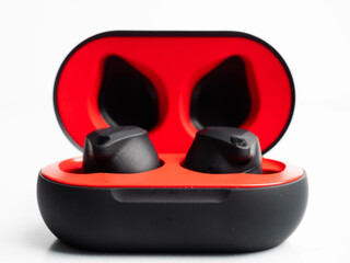 A pair of black wireless earphone with case