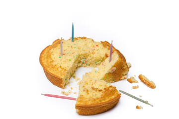 Confetti birthday cake in pieces with candles and crumbs isolated on white.