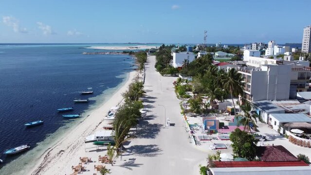 Drone Flight Along the Street in the Maldives. Beach and White Sand, Houses on the Island. Maafushi