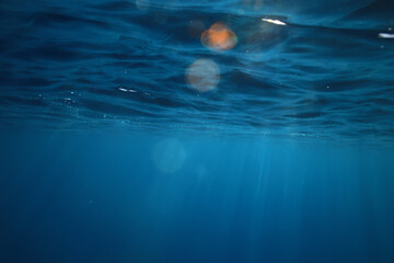 ocean underwater rays of light background, under blue water sunlight