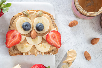 Kids breakfast or lunch or snack toast with peanut butter spread, banana, strawberry and blueberry...