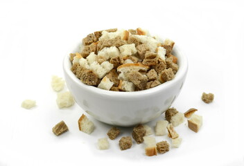 Bread croutons on a white background. Scattered pile of homemade rye bread croutons isolated on white background top view. Crispy bread cubes, dry rye crumbs, rusks, crouoton or brown roasted crackers