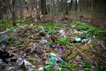 Naklejka na ściany i meble There is a lot of garbage in the forest. The concept of human pollution of forests and nature. A terrible dump in the woods.