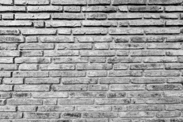 Old black and white brick wall background texture close up.