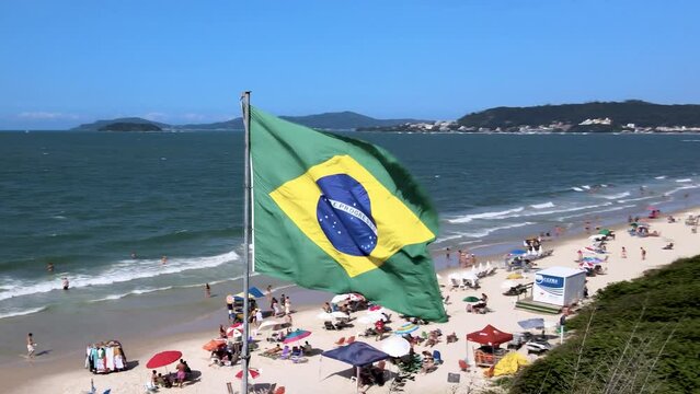 Aerial drone view of brazil flag hoisted fluttering in the wind on tropical beach tourist paradise
