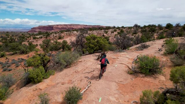 Bikers riding mountain bikes in unearthly landscape in the Utah mountains on a dirt road. Extreme sport. Top aerial view. Drone footage. USA wild nature