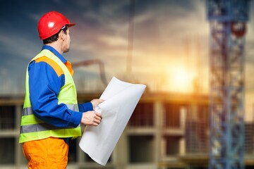Engineer or architect with building plan at construction site, business, building, industry, people concept.
