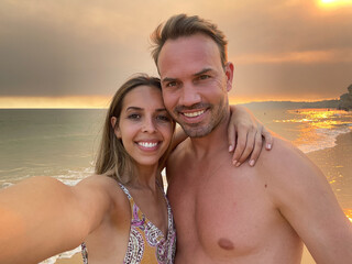 Happy couple lying on sandy beach