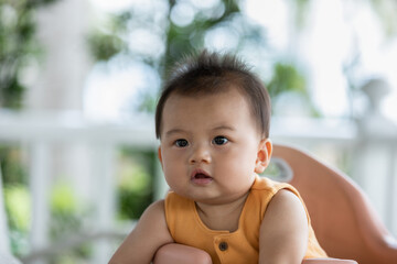 Happy asian newborn baby sit on baby chair smile and laughing with parent or family at home.Adorable baby boy cheerful enjoy with good moment in warmth place.growth with good Emotional Quotient