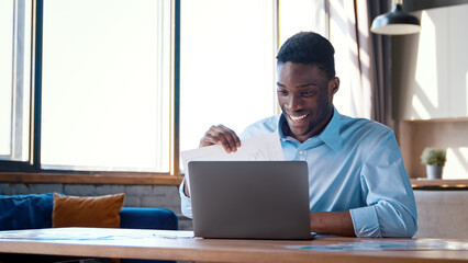 Young businessman in shirt showing his projects to colleague via video call remotely