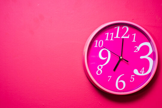 clock on a pink bright wall
