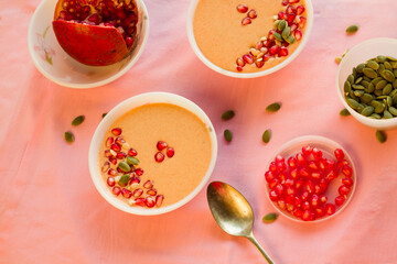 Bowls of vanilla flavored custard pudding with pomegranate seeds on top. Top down view.