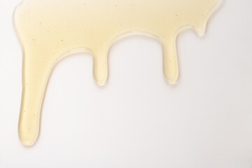 Honey flows. Drops of yellow syrup flow. Natural product and sweet drink. Isolated on white background.