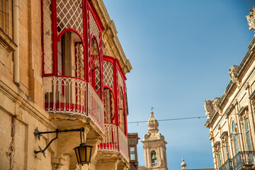 Fototapeta na wymiar Red doors and windows in the beautiful city center of Mdina, Malta