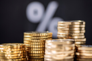 Stack with coins and percent sign in background