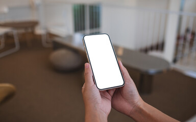Mockup image of a woman holding mobile phone with blank desktop screen