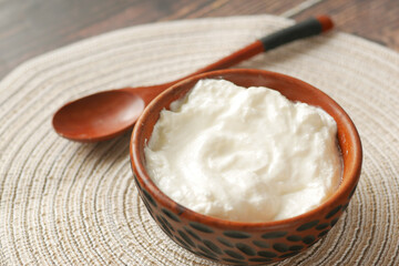 fresh yogurt in a wooden bowl on table 