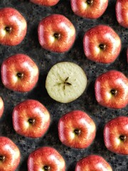 Pattern of red apples and slice of apple with star on black concrete background. Creative flatlay with summer fruit.