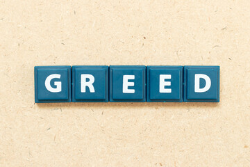 Tile alphabet letter in word greed on wood background