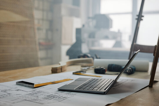 Close up background image of opened laptop on table in hazy carpenters workshop, copy space