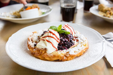 pancake with whipped cream and blueberries sprinkled with powdered sugar