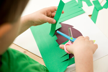 Hedgehog hides in the grass. A little boy cuts paper. Liberation of animals. Implement to develop fine motor skills, learn to cut with scissors, knowing animals. © Birute