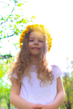 Ukrainian girl. A little curly-haired girl in a wreath of dandelions.
