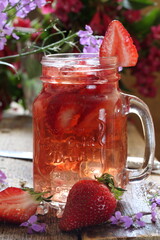 Strawberry drink with ice cubes on wooden table	
