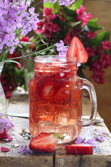 Strawberry drink with ice cubes on wooden table	
