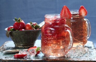 Strawberry drink with ice cubes on wooden table