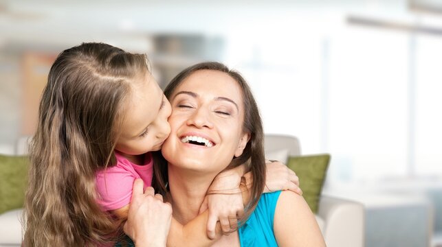Cheerful preschool kid hugging happy mom with love, gratitude, tenderness.