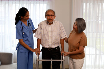 Asia woman nurse helping patient physical therapy at home.