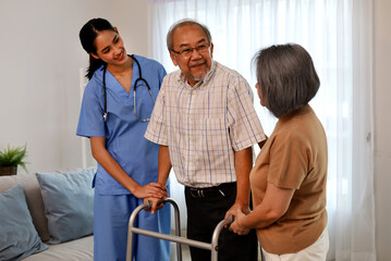 Asia woman nurse helping patient physical therapy at home.