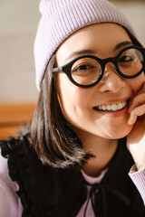 Young asian woman in eyeglasses smiling and looking at camera