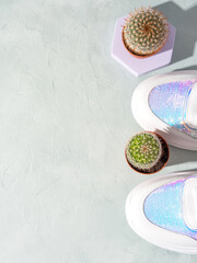 Fototapeta na wymiar White female pastel sneakers with cactus on turquoise background