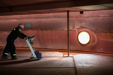 Male worker inspection floor scan tank external floating of rust  wall lose thickness bottom plate in to work inside confined