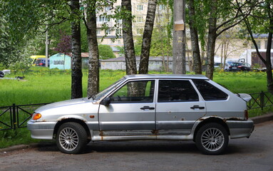 An old rusty silver Soviet car in the courtyard of a residential building, Podvoysky Street, St. Petersburg, Russia, May 2022