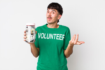 hispanic volunteer shrugging, feeling confused and uncertain. donations concept