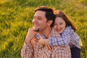 Smiling little girl hugging her father outside