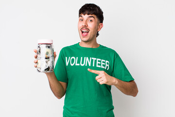 hispanic volunteer looking excited and surprised pointing to the side. donations concept
