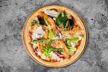 Sliced spicy tasty pizza with onion on a rustic table.
