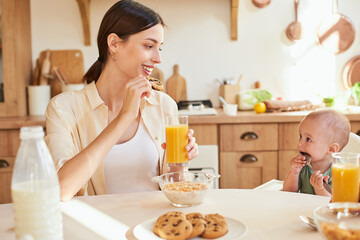 A beautiful young mother with a young son have breakfast together.