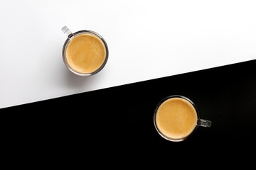 Two cups of coffee on black and white background. Espresso, arabica, ristretto in glass. Top view,...