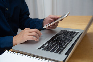 Fototapeta premium Close up Business man using laptop for do math finance on wooden desk, tax, accounting, statistics and analytical research concept
